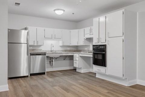 A modern kitchen with white cabinets and stainless steel appliances.