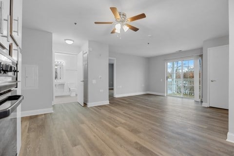 A spacious room with a ceiling fan and lighting fixtures.