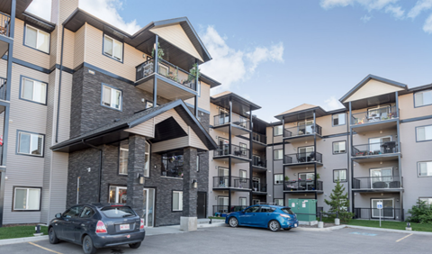 an apartment building with cars parked in front of it