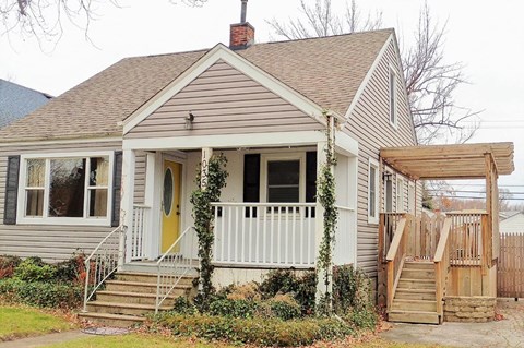 A house with a yellow door and a porch.