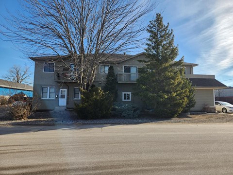 A house with a car parked in front.