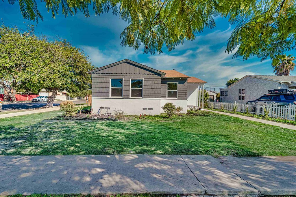 a house with a lawn and a sidewalk in front of it