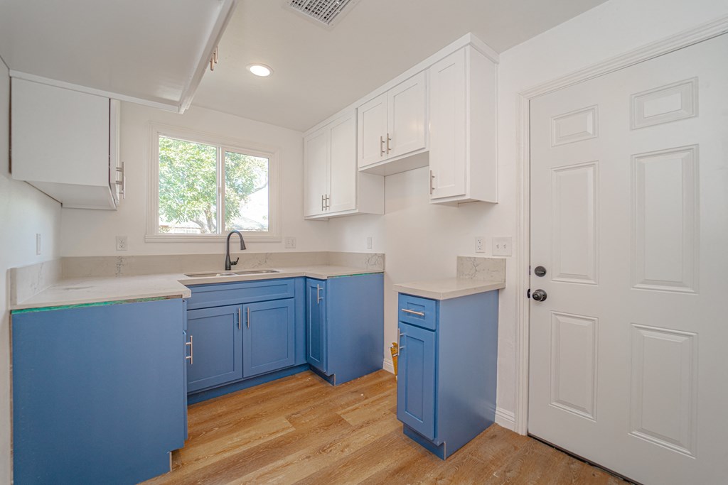 a kitchen with blue and white cabinets and a door