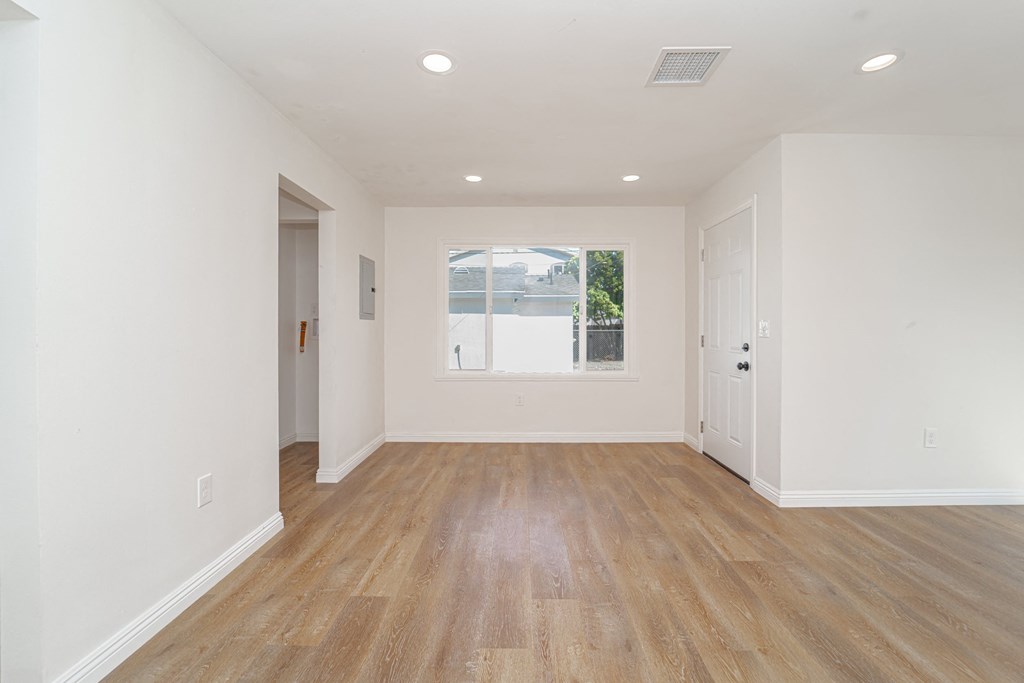 an empty living room with white walls and a window