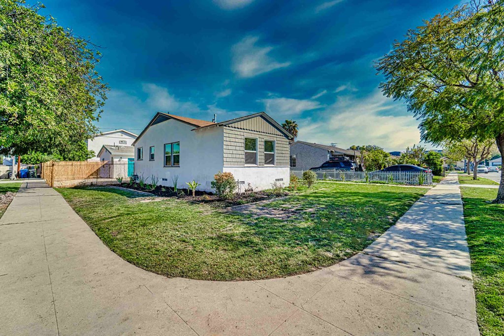 a white house with a yard and a sidewalk