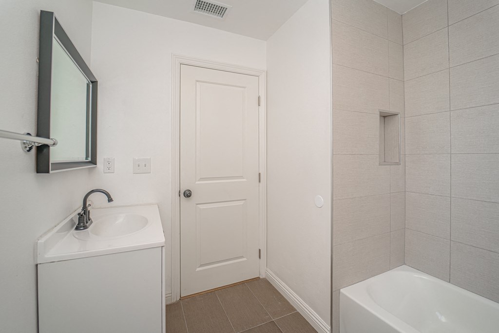 a bathroom with a sink and a shower and a door
