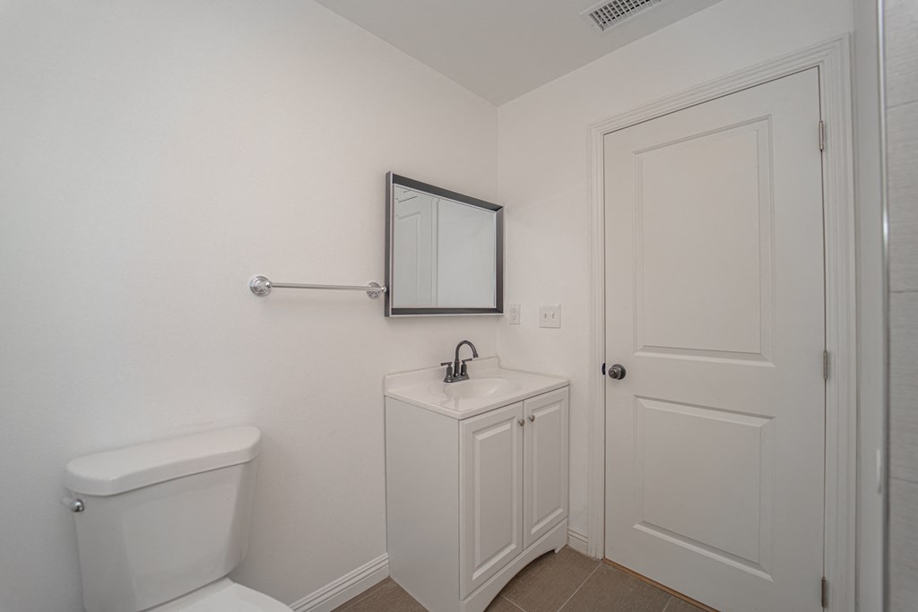 a bathroom with a toilet and a sink and a white door