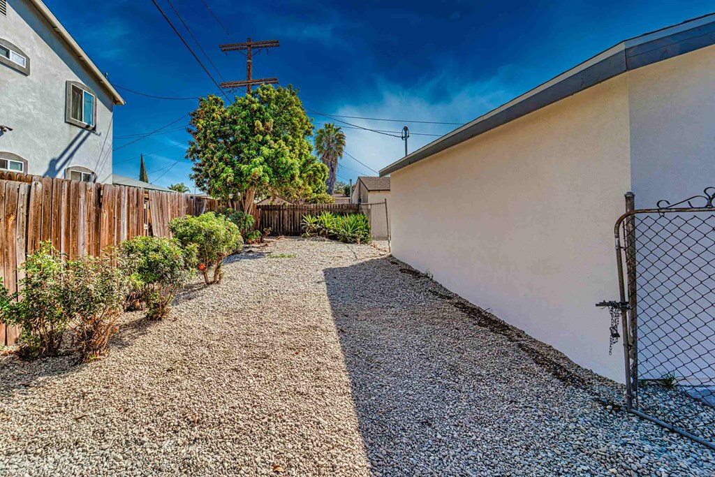 a yard with a fence and a chain link fence next to a house
