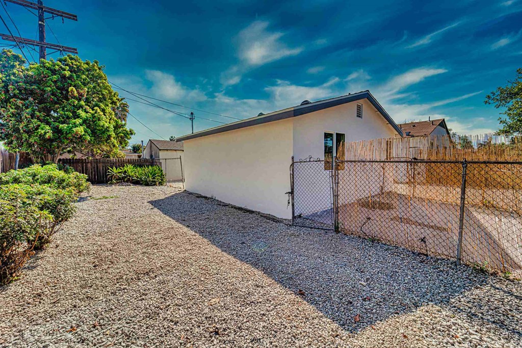 a white house with a fence and a chain link fence