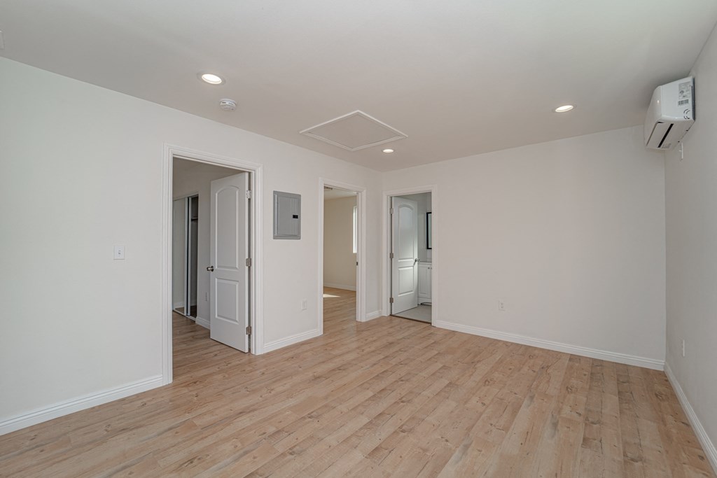 a living room with a hard wood floor and white walls