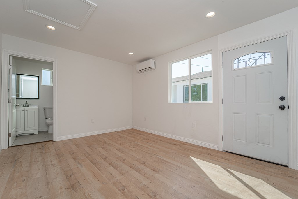 an empty living room with white walls and a white door