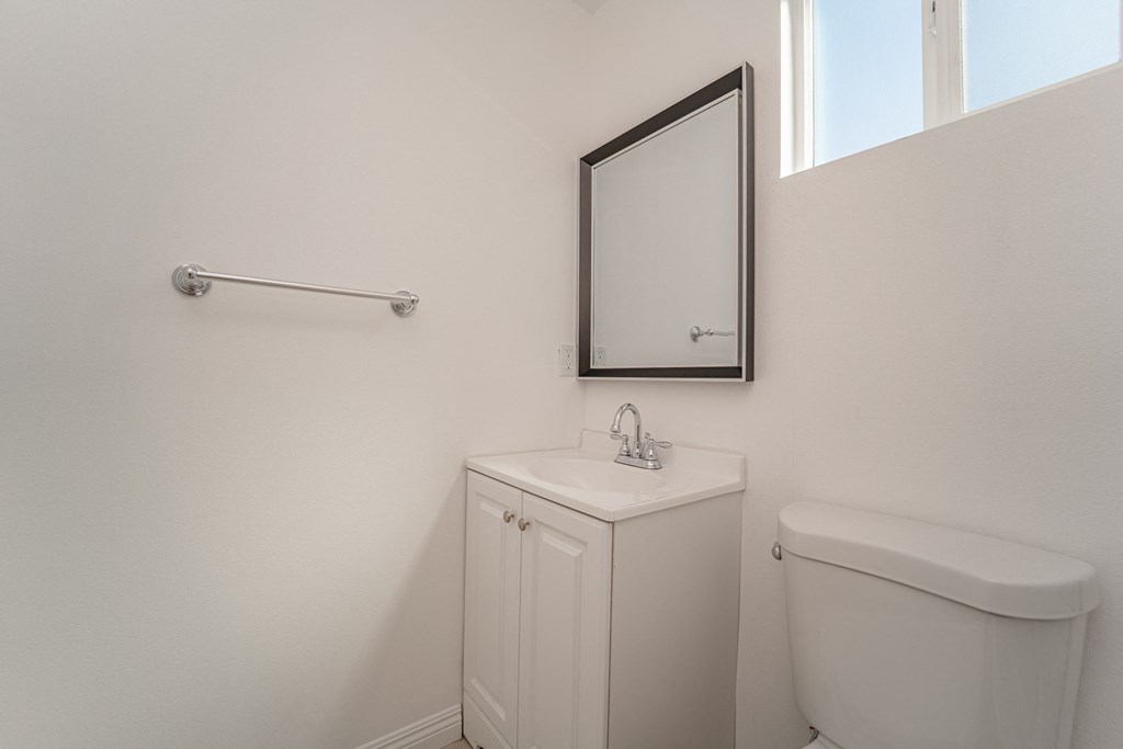 a bathroom with a toilet and a sink and a mirror