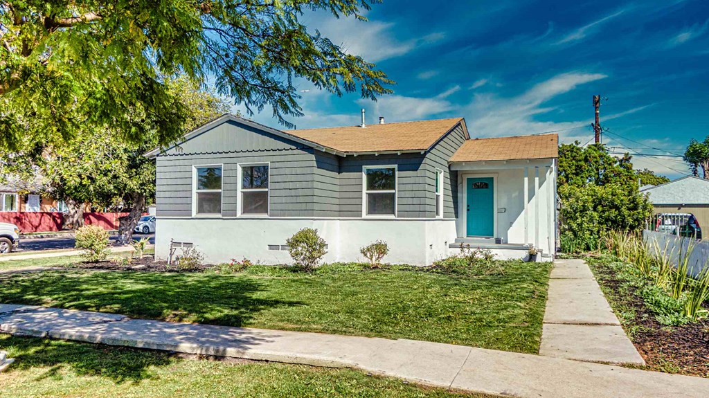 a blue and white house with a blue door and a sidewalk
