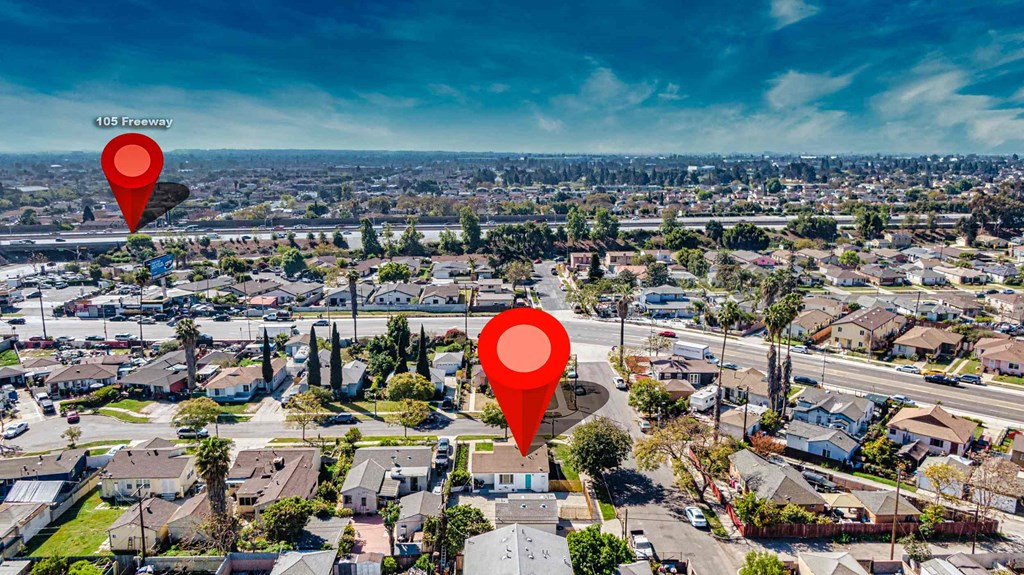 a aerial view of a neighborhood with a red arrow pinpointing a suburb with houses