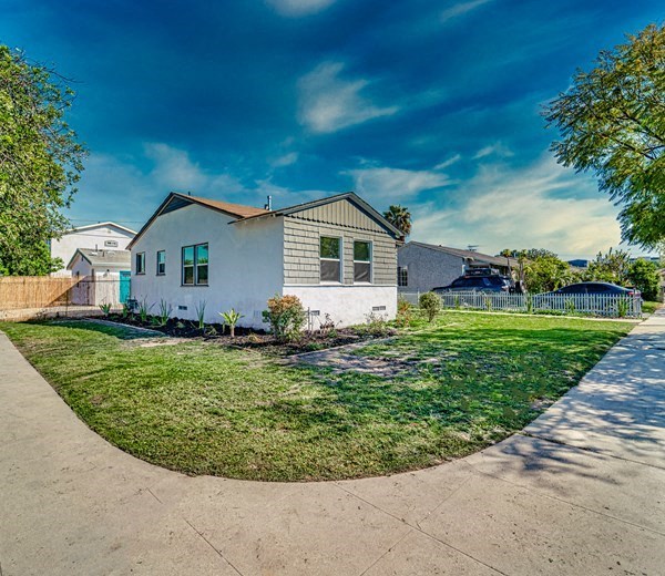 a white house with a yard and a sidewalk