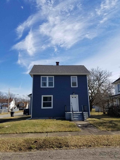 A blue house with a white door and windows.