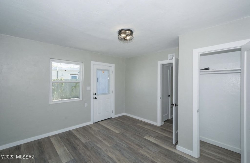 an empty room with white walls and a white door and a window