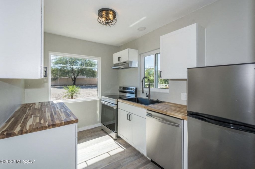 an updated kitchen with stainless steel appliances and a window