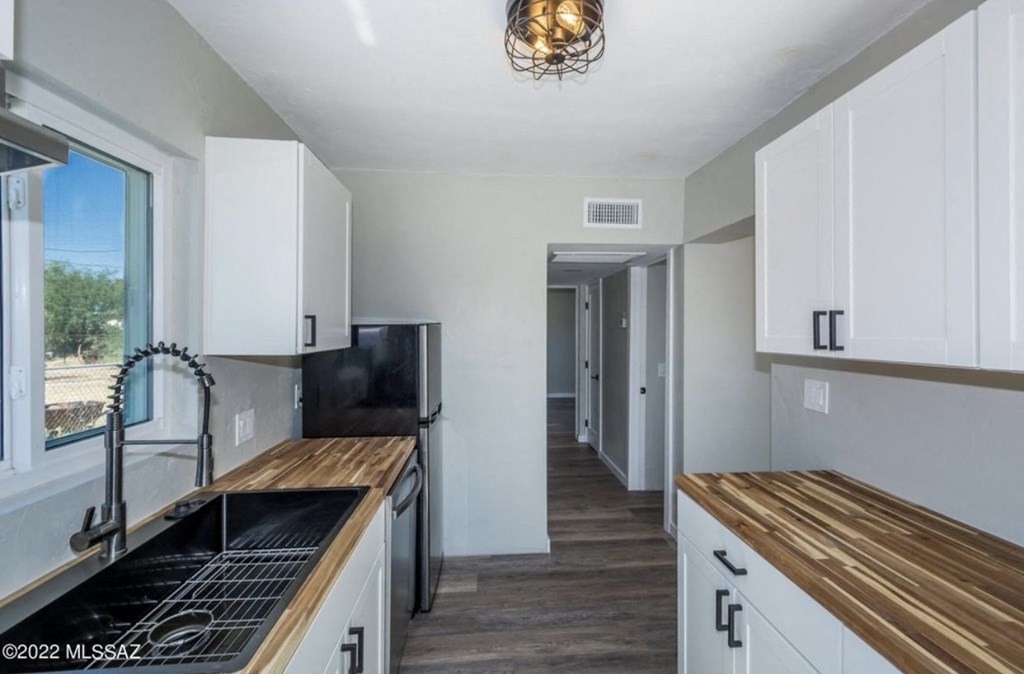 a kitchen with white cabinets and a counter top and a sink