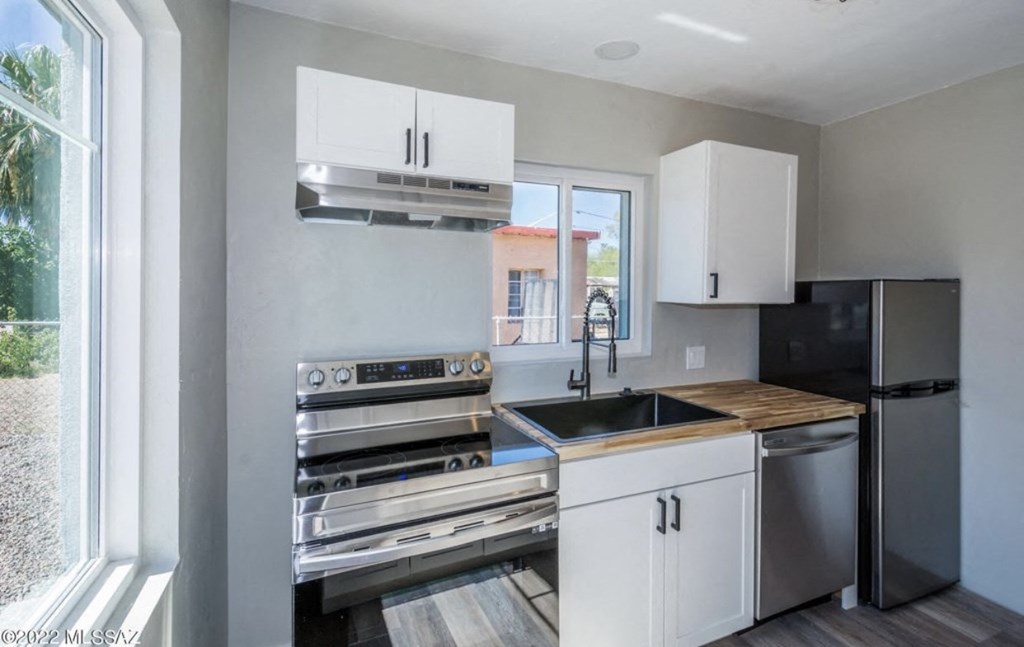 a kitchen with white cabinets and stainless steel appliances