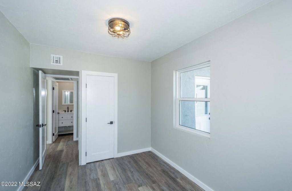 an empty bedroom with white walls and a window