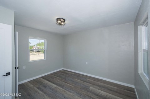 an empty living room with wood floors and a window