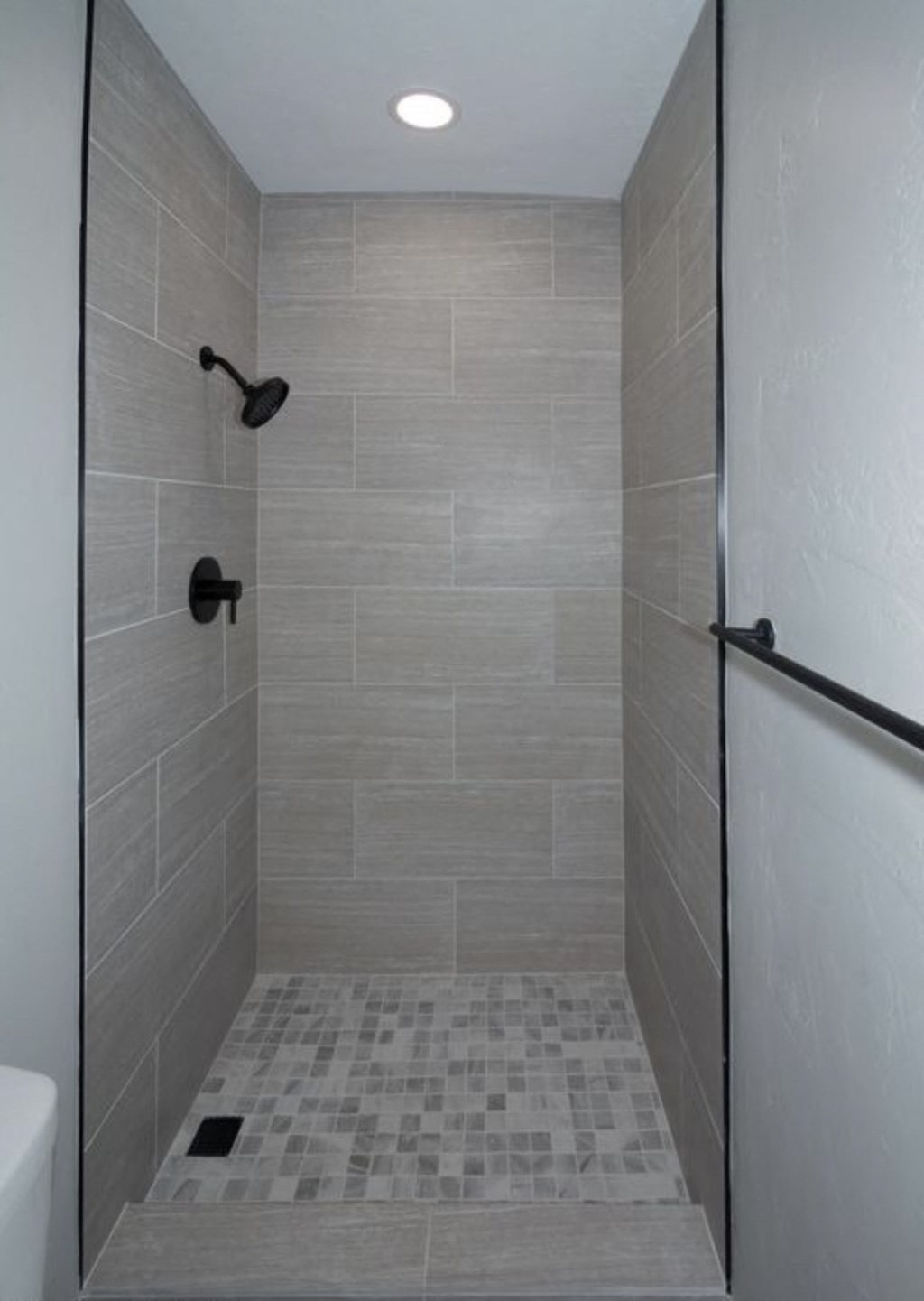 a bathroom with a tiled shower and a sink