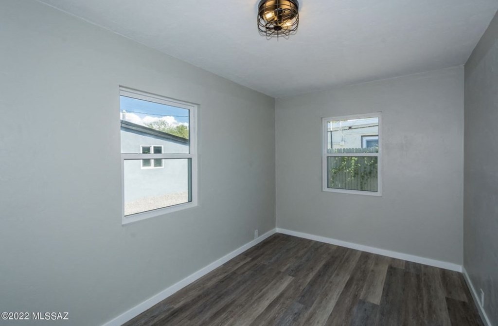 an empty room with wood floors and a window