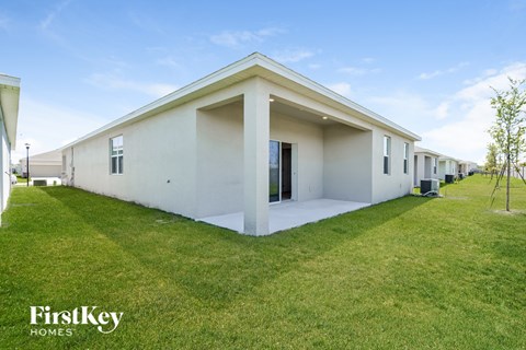 a row of white houses with a lawn and grass