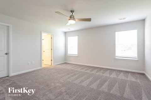 a living room with carpet and a ceiling fan