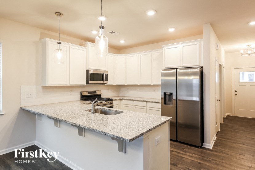 a kitchen with white cabinets and a granite counter top