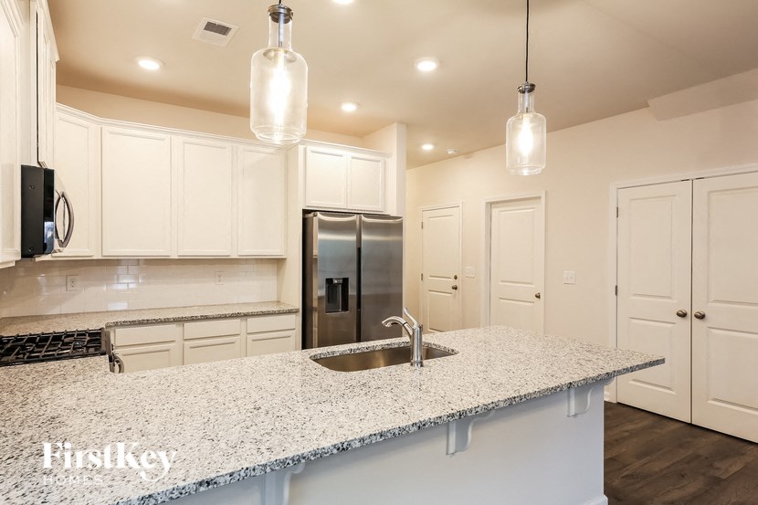 a kitchen with white cabinets and a counter top