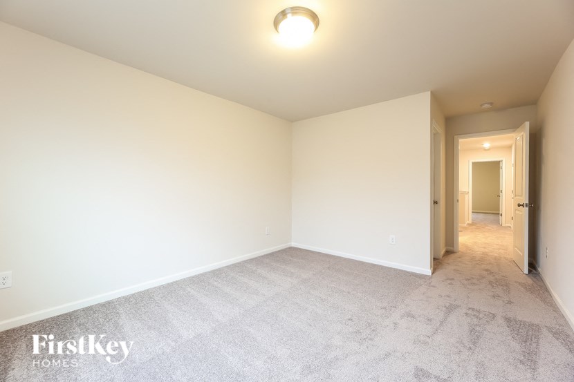 a spacious living room with white carpet and white walls
