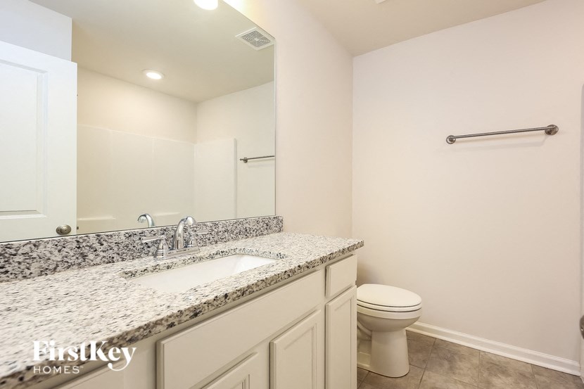 a bathroom with a toilet and a sink and a mirror