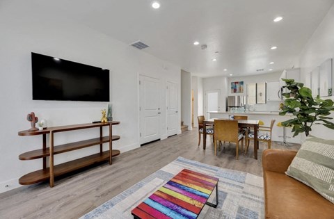 a living room with a tv and a dining room table