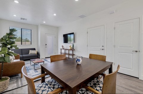 a dining room and living room with a wooden table and chairs