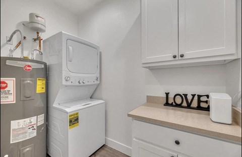 the laundry room has a washer and dryer and a counter with a refrigerator