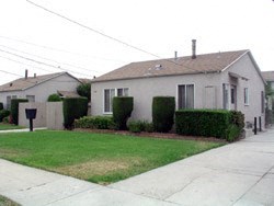A house with a grey roof and a white fence.