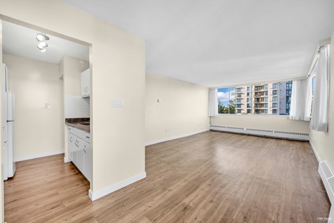 A spacious room with wooden floors and white walls.