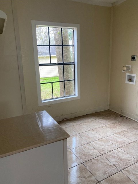 an empty kitchen with a window in it