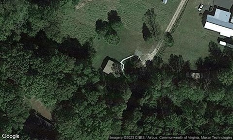 A satellite image shows a rural area with a few buildings and a winding road.