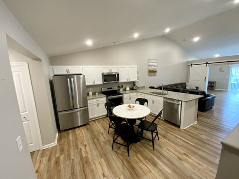 a kitchen and dining area with stainless steel appliances and a table