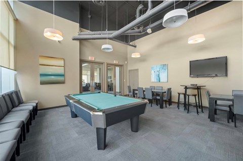 A room with a pool table and a television.