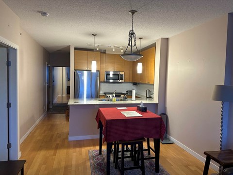 A kitchen with a table and chairs in the foreground.
