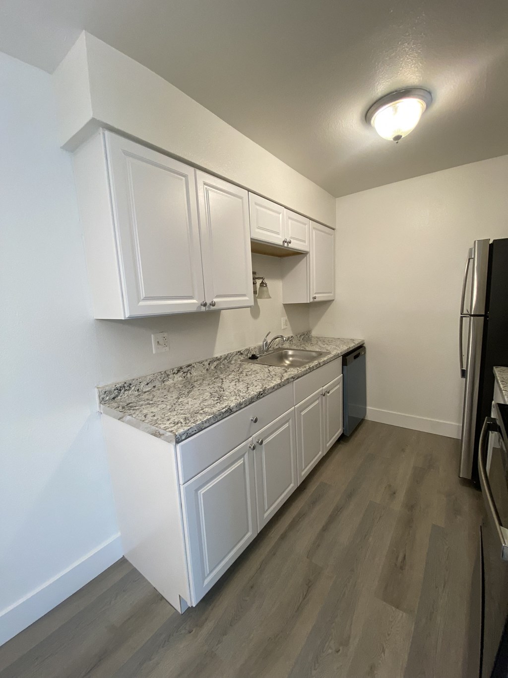 a kitchen with white cabinets and a granite counter top