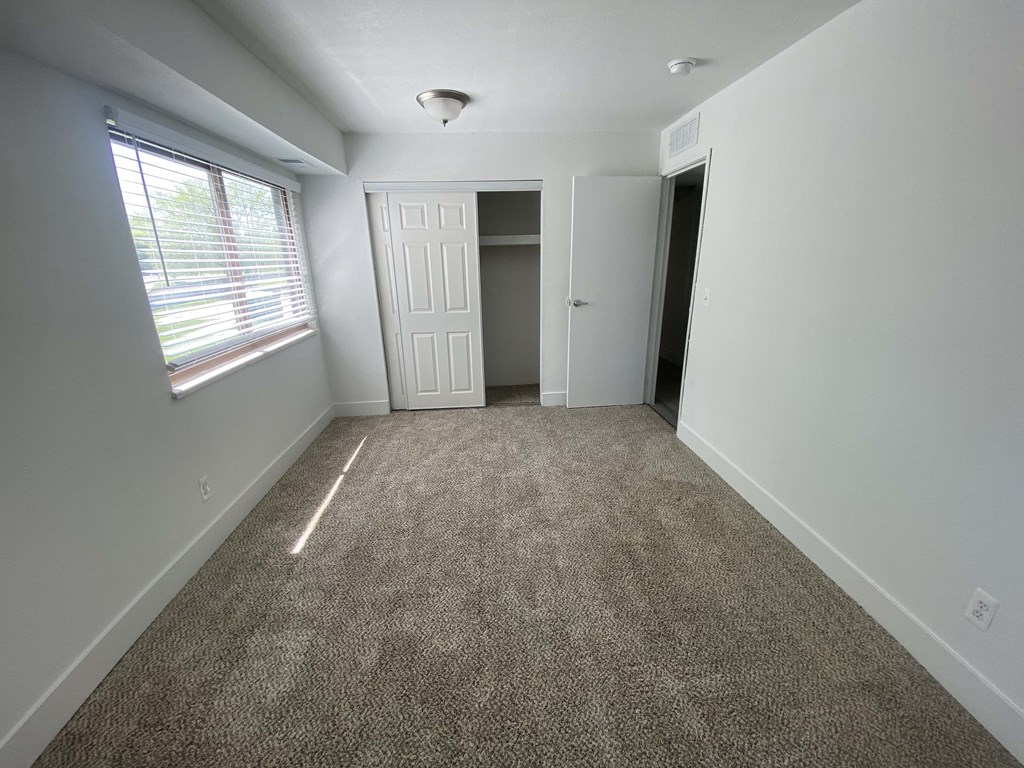 a empty room with carpet and a window
