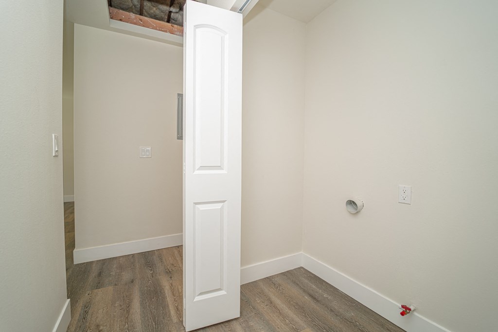 an empty room with a white door and wood floors