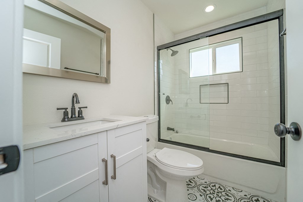 a white bathroom with a shower and a sink and a toilet