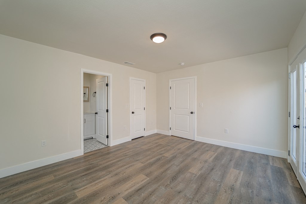 an empty living room with white walls and wood flooring