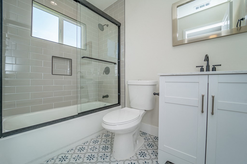 a white bathroom with a shower toilet and sink